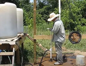 A PVC hand pump operates a large wash station as a demonstration of appropriate technology