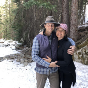 couple hugs in snow covered forest