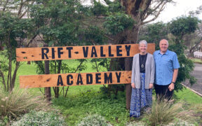 Dave and Debbie Bochman stand before the Rift Valley Academy sign